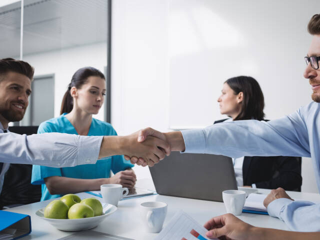 Doctors shaking hands with each other in meeting at conference room