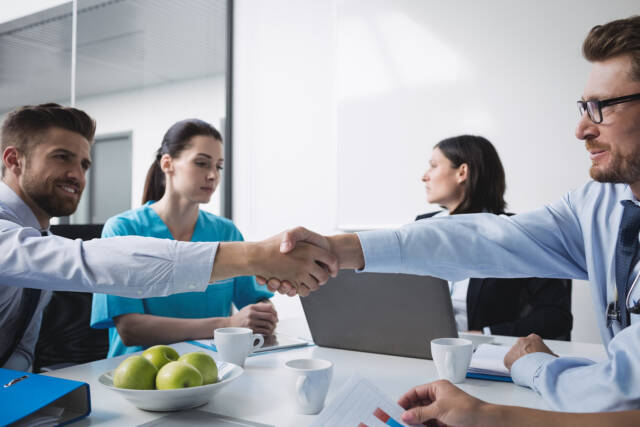 Doctors shaking hands with each other in meeting at conference room